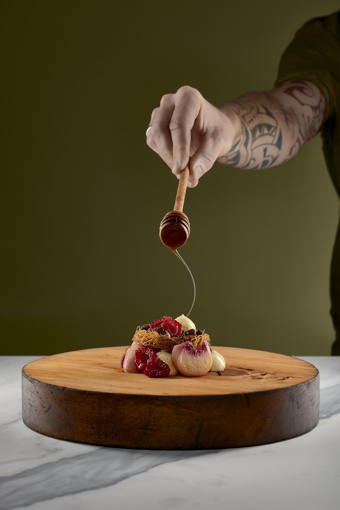Chef arranging plated dish on wooden board